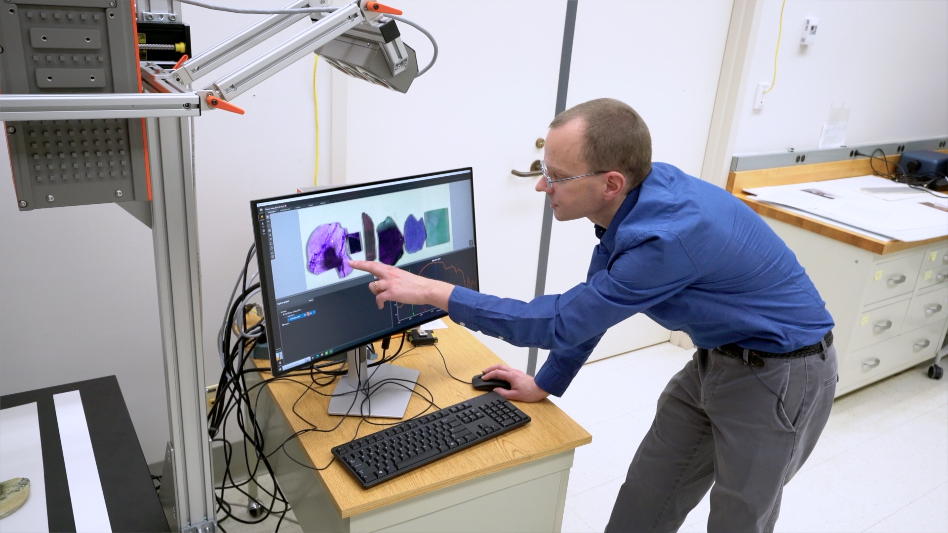 A man points at a screen showing spectrum analyzer software